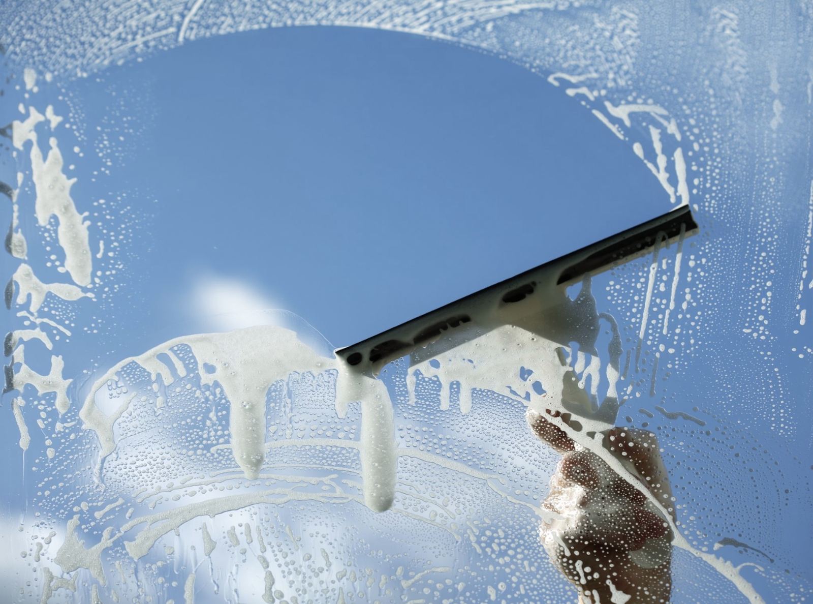Squeegee cleaning a sunny window